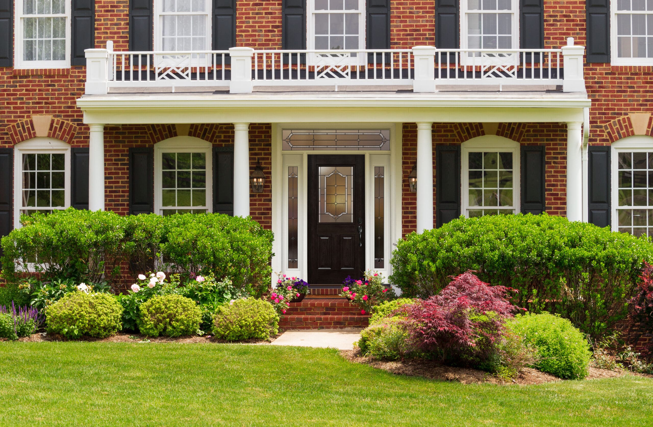 A home’s front, with a black front door and black window shutters in Ballwin, MO.